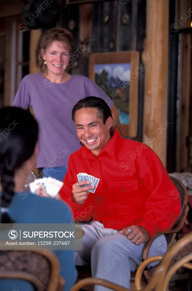 Friends Sitting In A Cabin Playing Cards