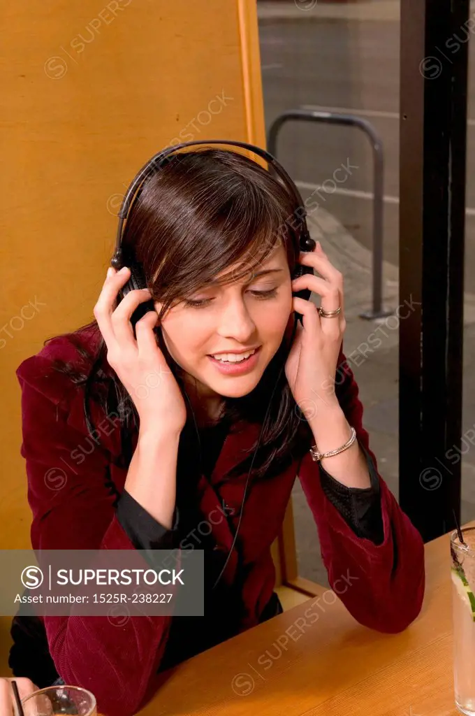 Hip Caucasian Girl Listening To Headphones In A Cafe
