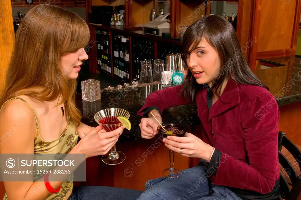 Fashionable Caucasian Girlfriends Drinking Cocktails At The Bar