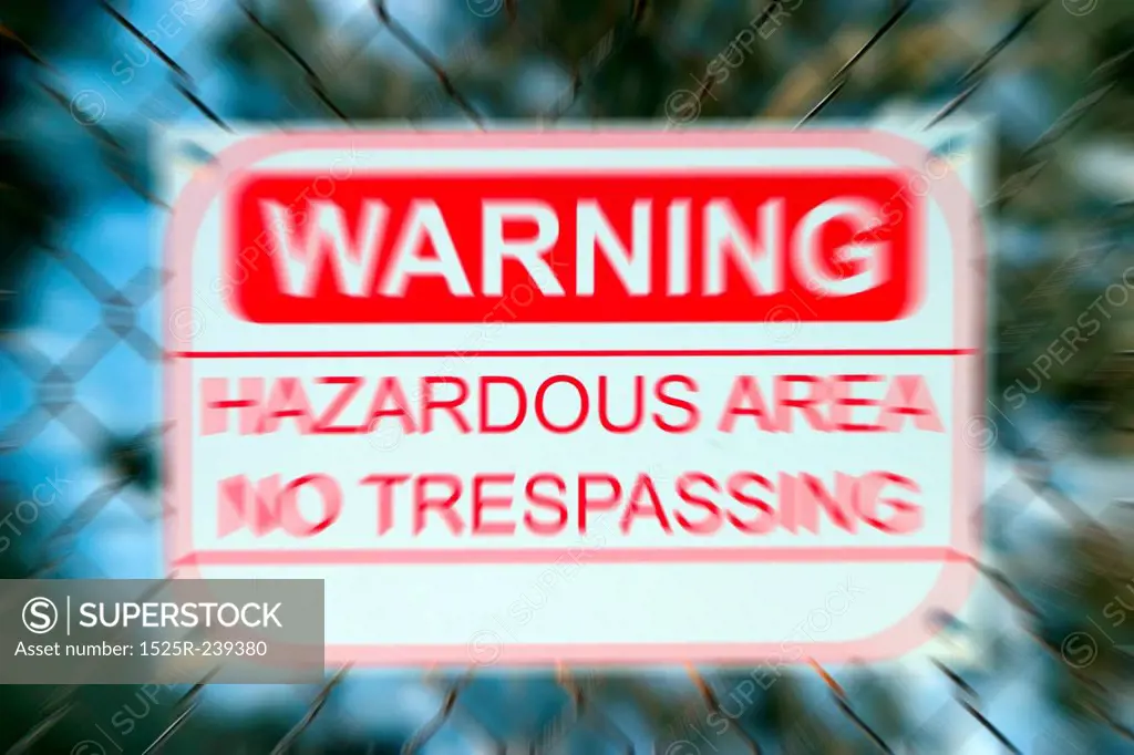 Warning Sign on Blurred Chainlink Fence