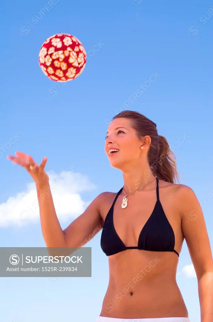Woman Tossing Red Ball Into the Blue Sky