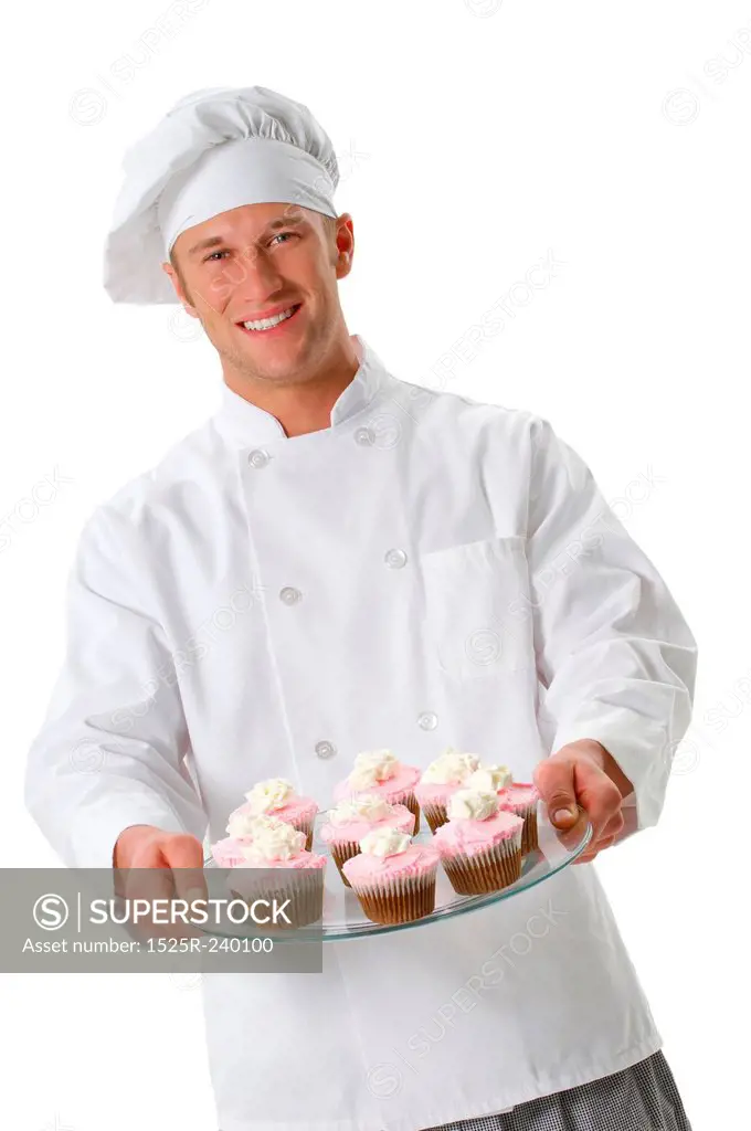 Chef in chefs whites and toque holding cupcakes