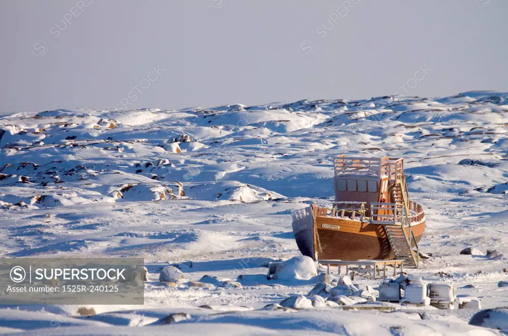 Wooden ship stranded in snow-covered remote field