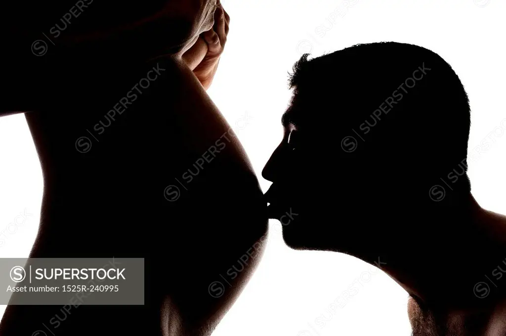 A man kissing a pregnant women's belly
