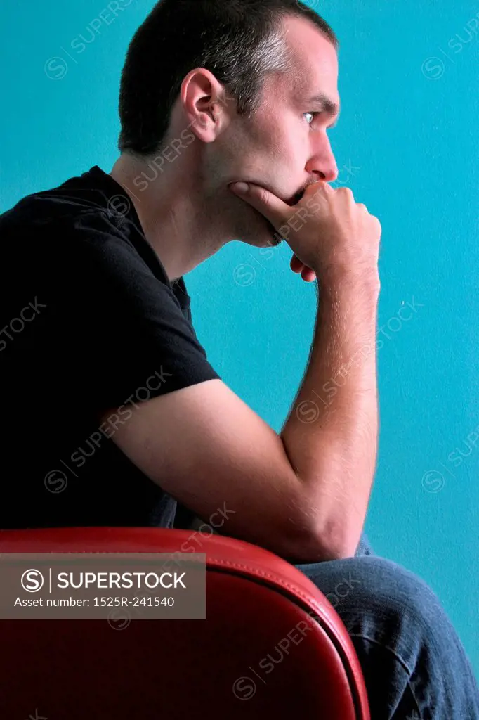 Man Sitting Pensively in Chair