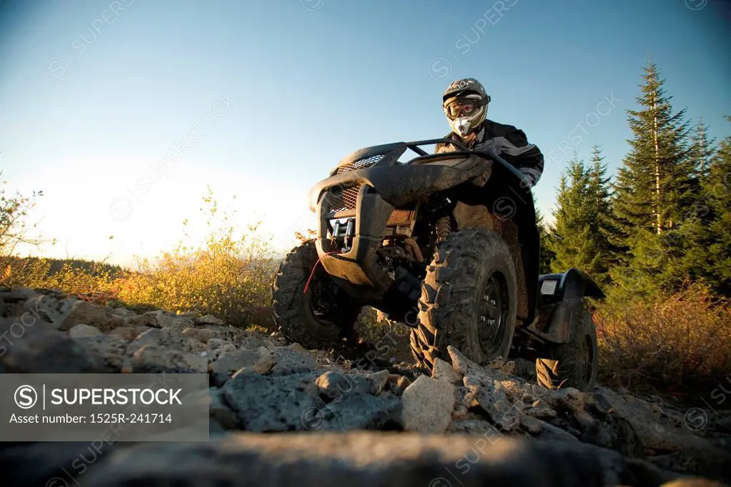 Man Riding ATV up Rocky Hill