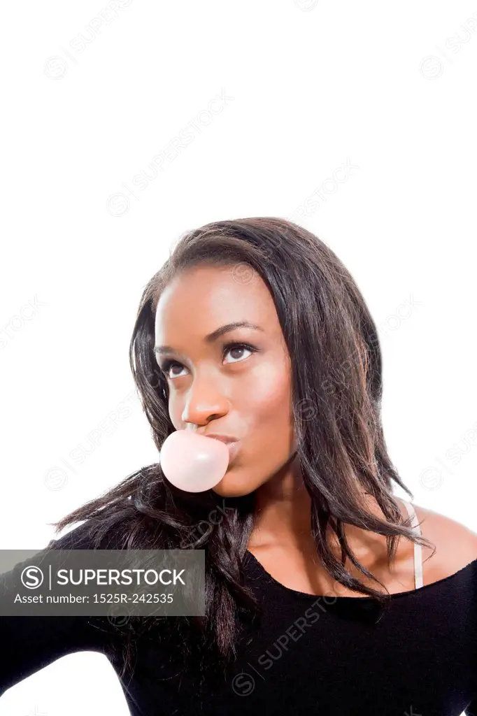 Attractive Young Woman Blowing Bubble Gum with Coy Expression