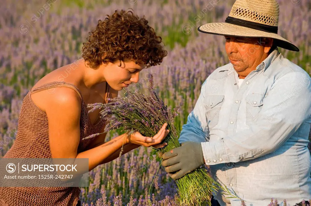 Woman Smelling Lavender Held By Worker