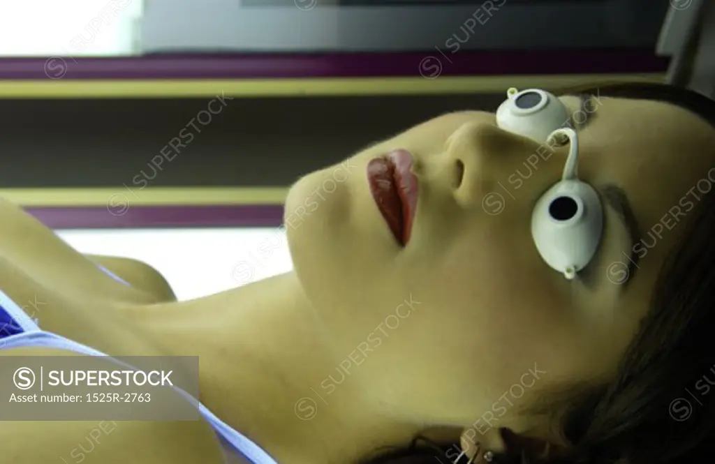 A young woman lying in a tanning capsule