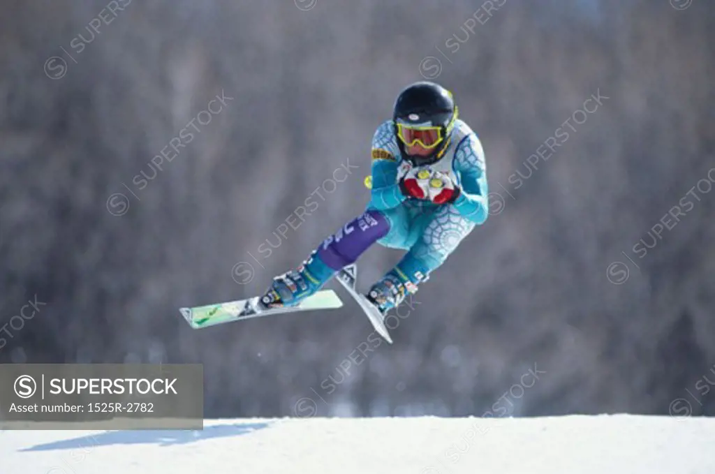A young skier in midair during a ski run