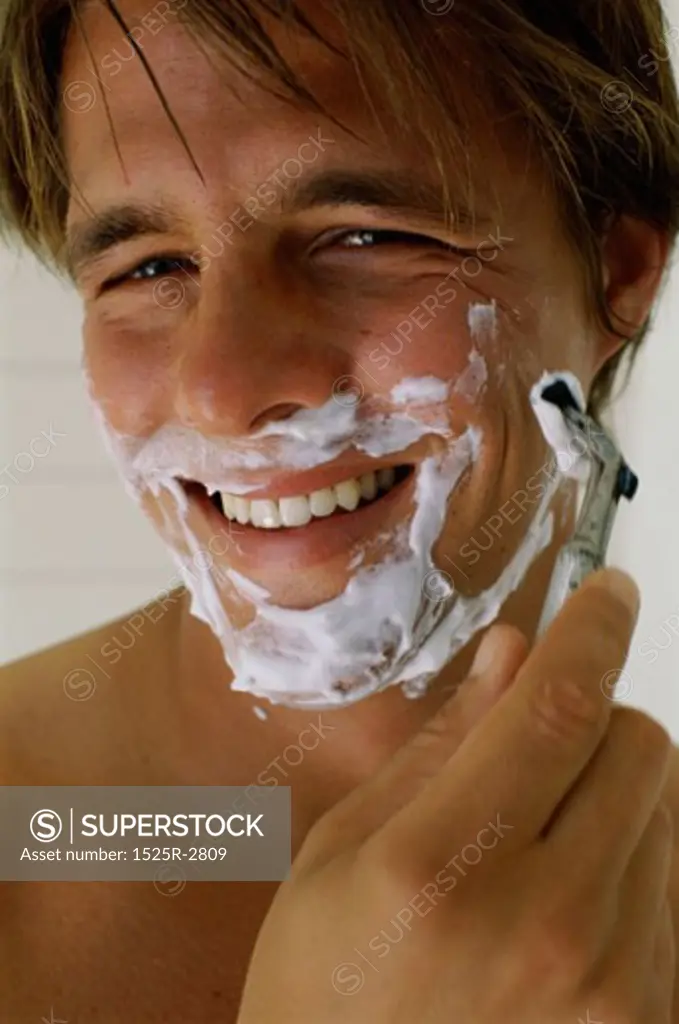 Close-up of a mid adult man shaving