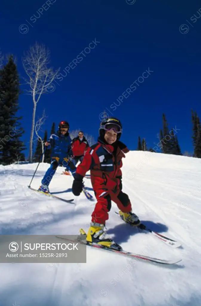 Couple skiing with their daughter on a snowy hill
