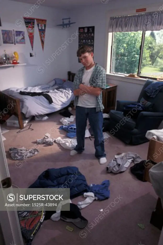 Boy Standing Defiantly In Messy Room