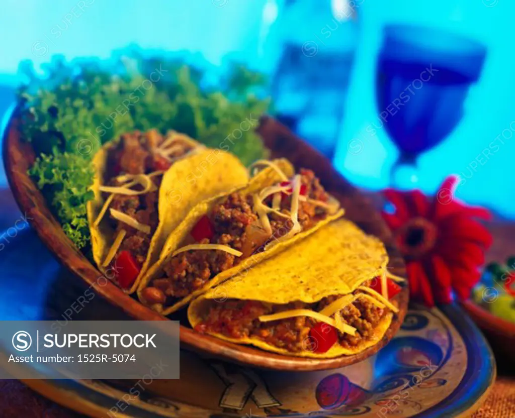 Platter of tacos served with lettuce greens