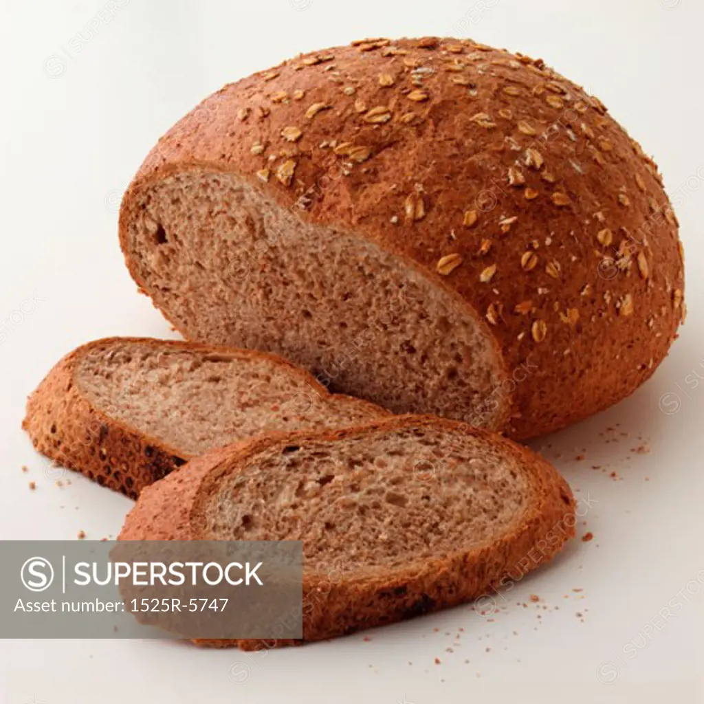 Close-up of a loaf and slices of brown bread
