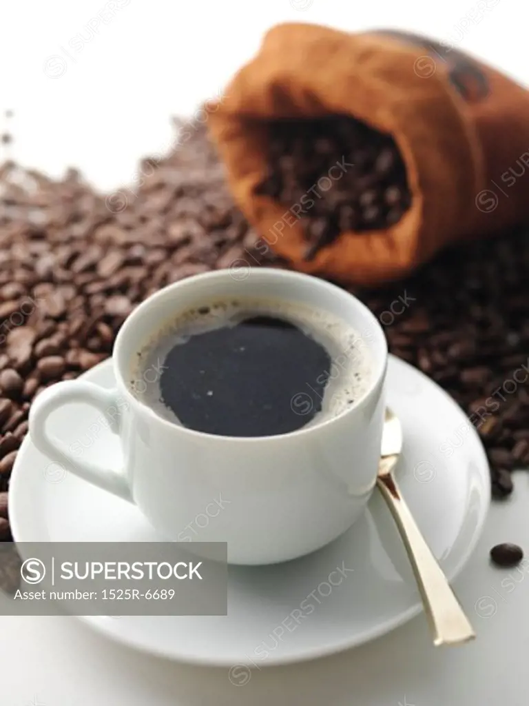 Close-up of a cup of espresso with coffee beans