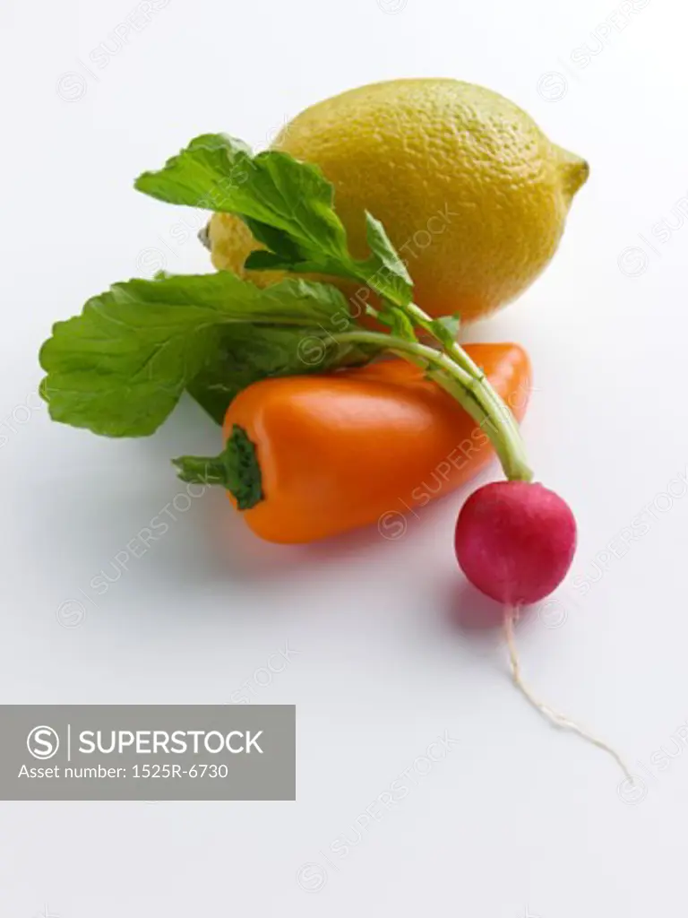 Close-up of a lemon with an orange bell pepper and a radish