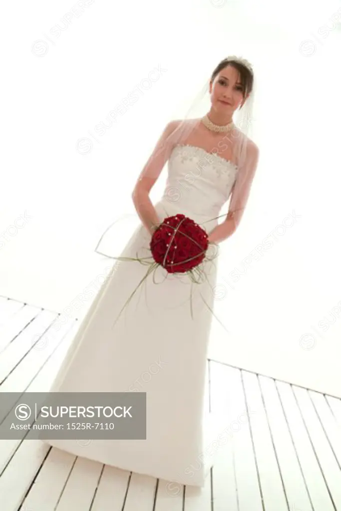 Portrait of a young bride holding a bouquet of roses