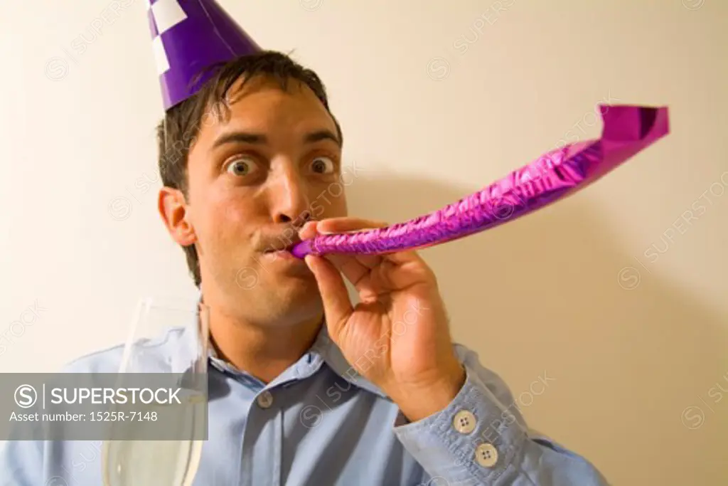 Close-up of a man blowing a party favor