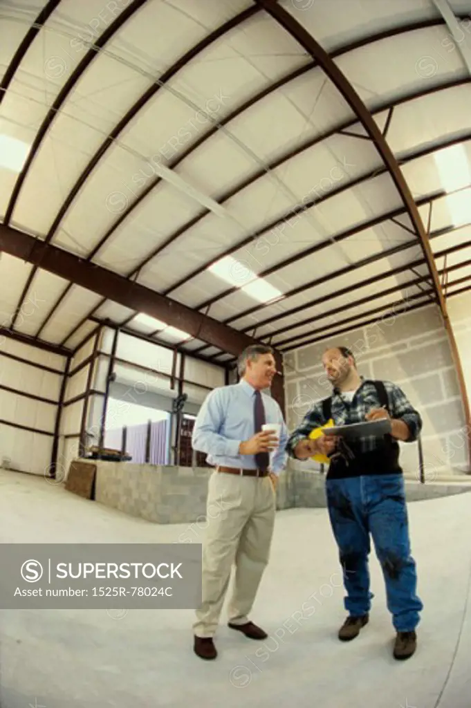 Low angle view of two mature men standing in a warehouse