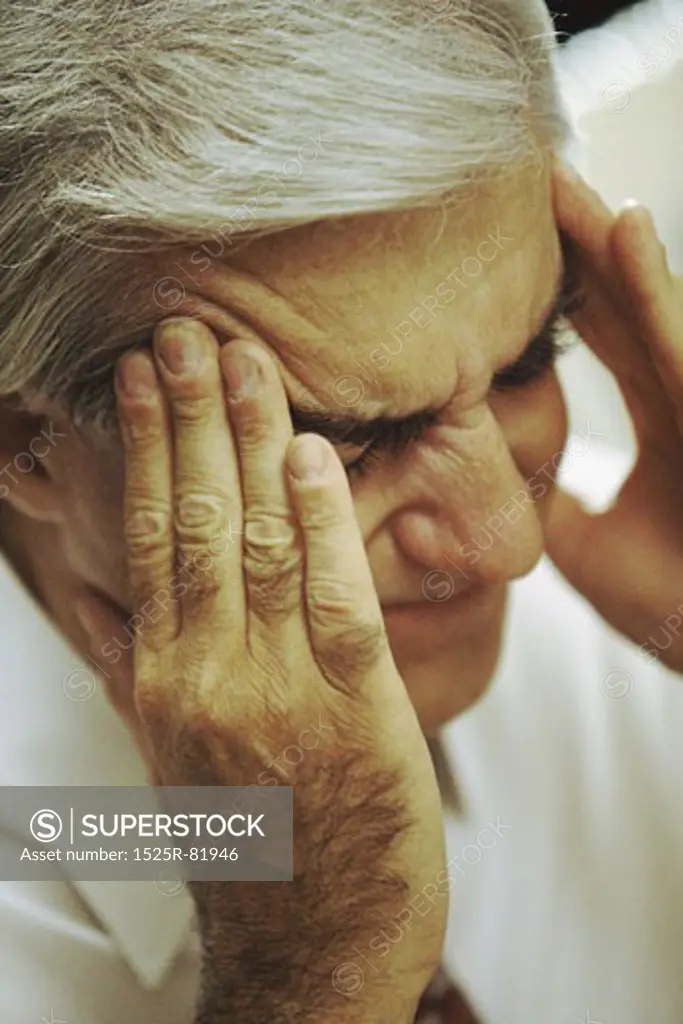 Man holding the side of his head in pain