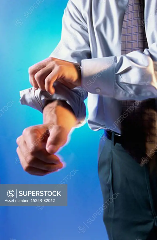 Close-up of a businessman rolling up his sleeves