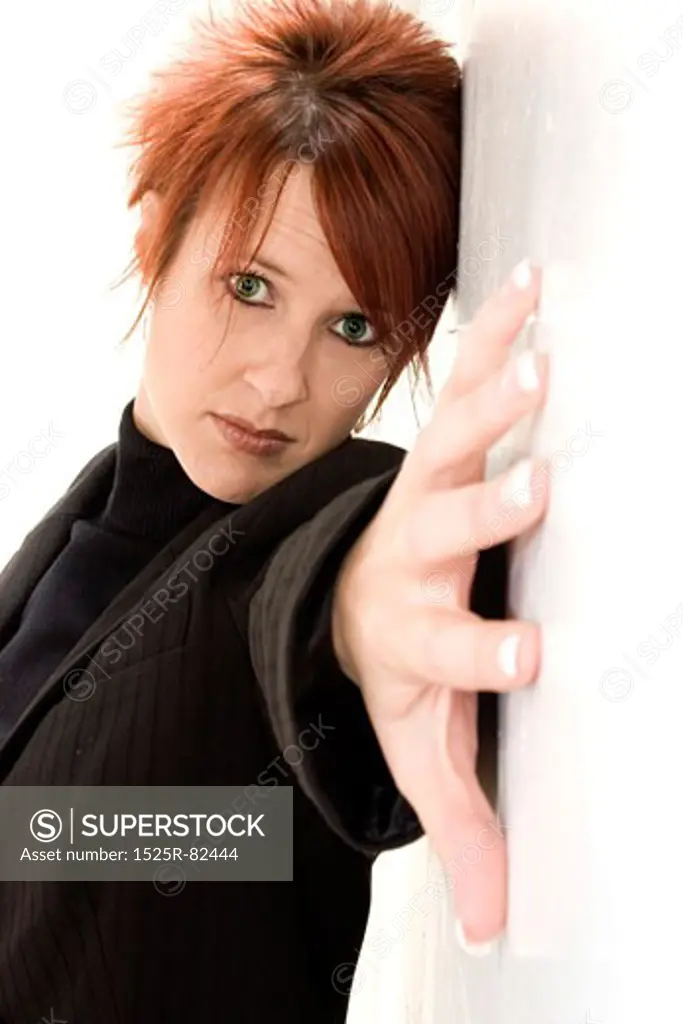 Mid adult woman with her hand stretched across a wall