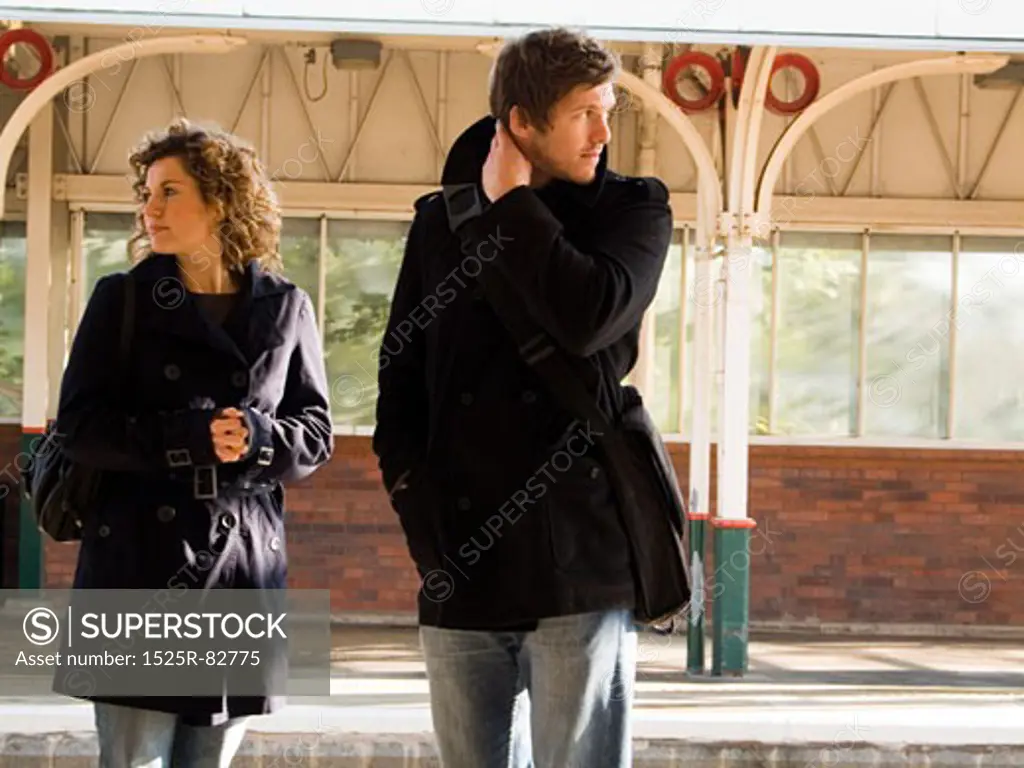 Young couple standing at a railroad station platform