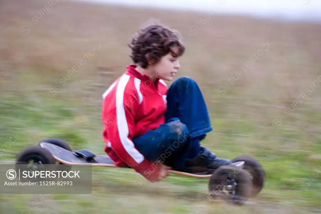 Boy riding a mountain board in a field
