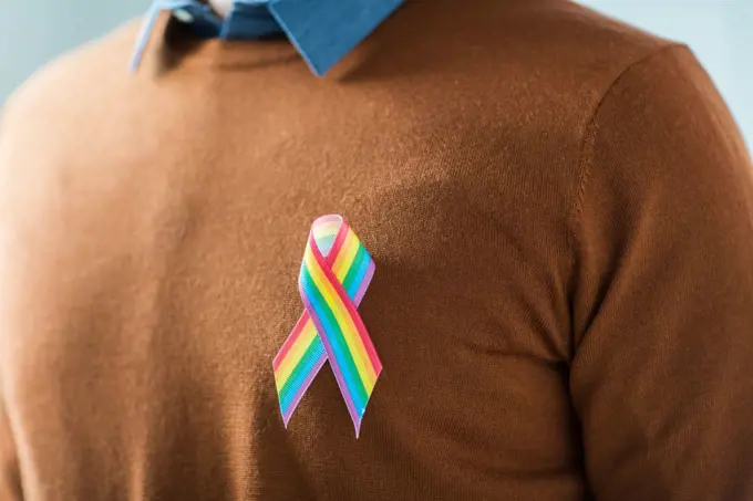 lgbt, same-sex relationships and homosexual concept - close up of man with gay pride rainbow awareness ribbon on his chest. man with gay pride rainbow awareness ribbon. man with gay pride rainbow awareness ribbon