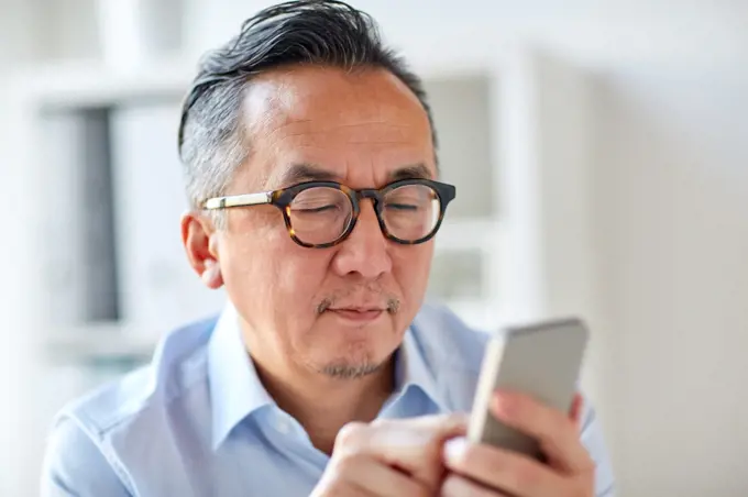 business, people, communication and technology concept - close up of businessman texting on smartphone at office. businessman texting on smartphone at office
