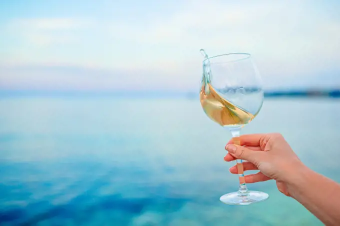 Glass of white wine on tropical beach on the sunset. Glass of white wine on tropical beach