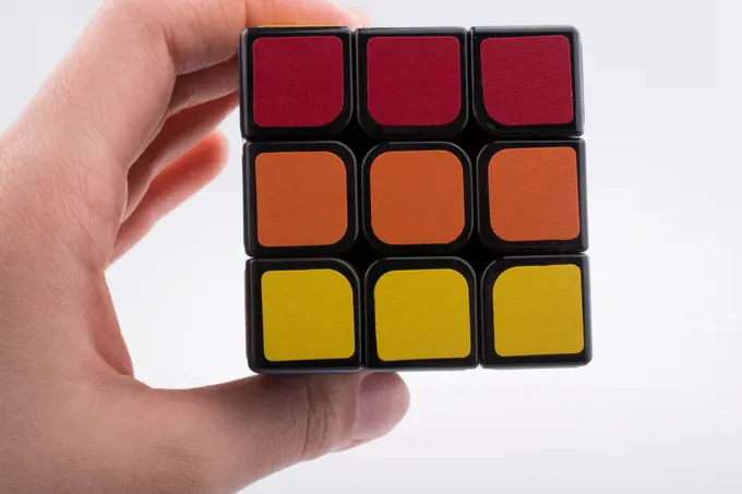 hand holding Rubik&rsquo;s cube on white background