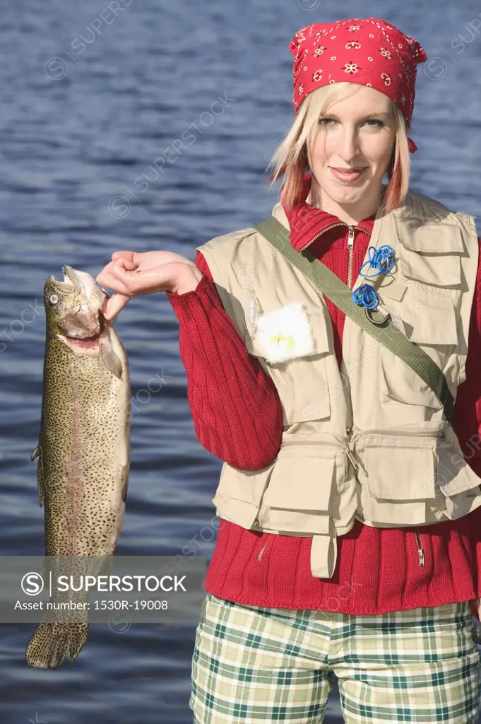 Woman holding up a large trout.