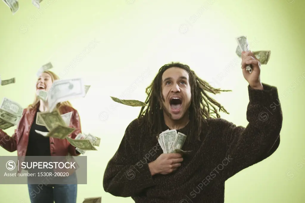 Man and woman catching falling money.