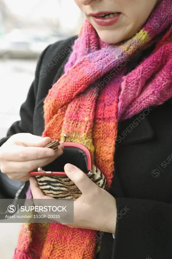 A woman counts the change in her coin purse.