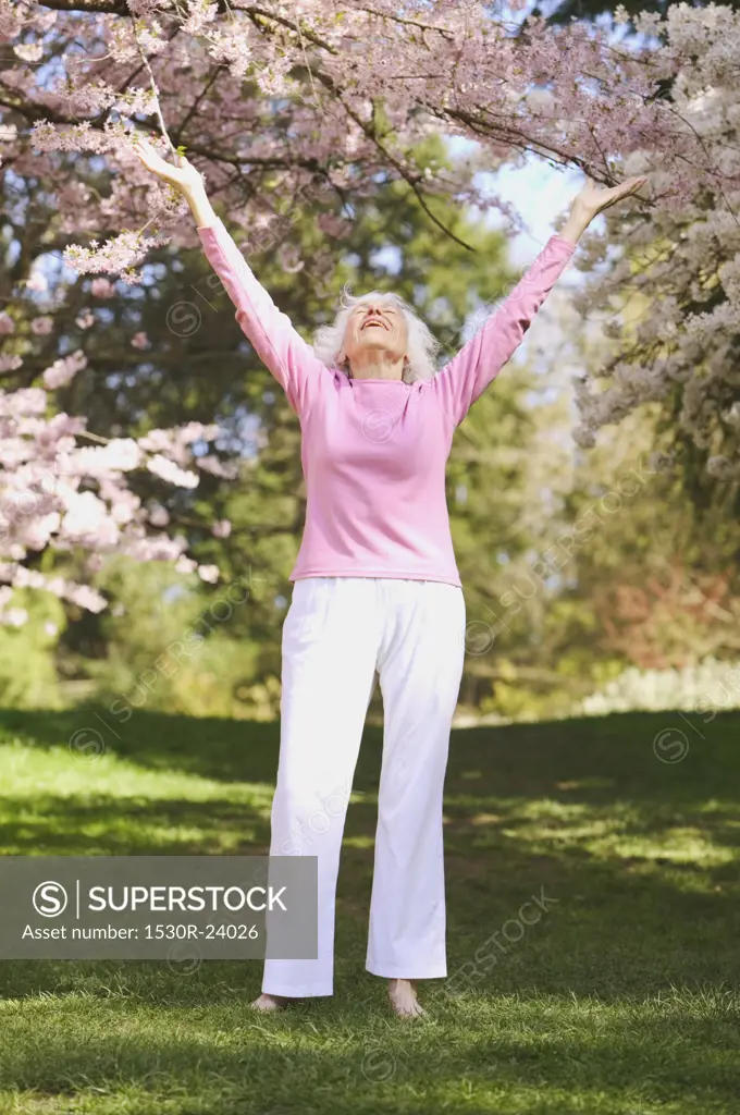 A senior woman with outstretched arms