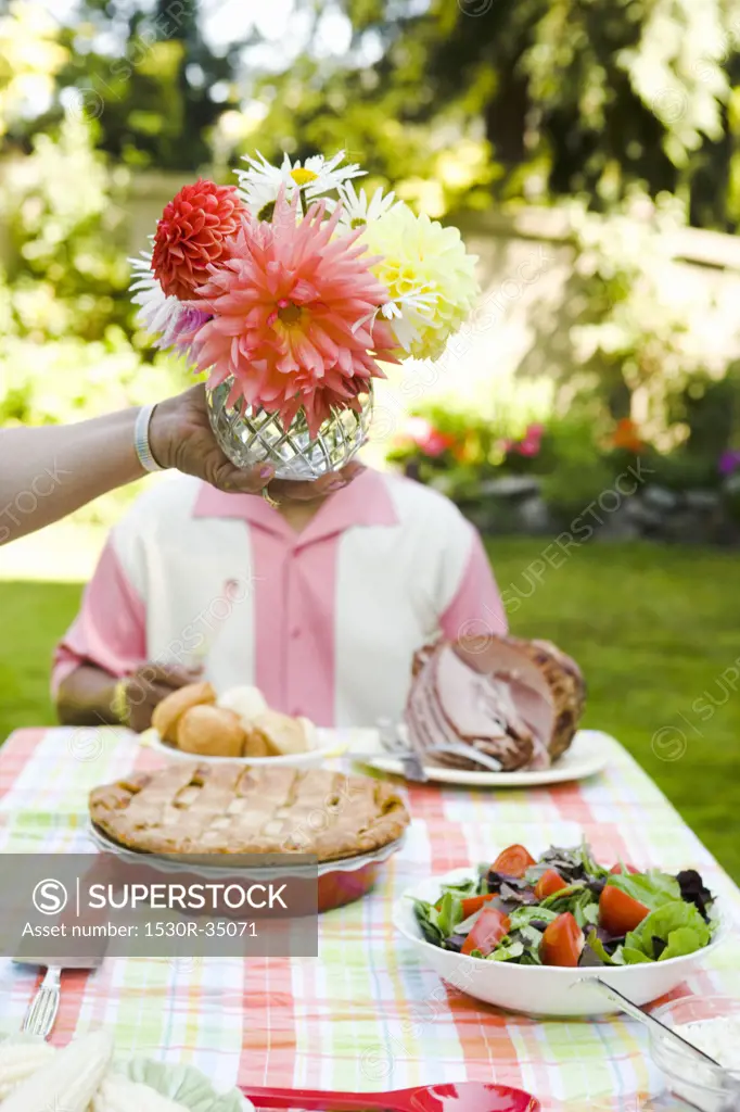 Flower centerpiece held above picnic table