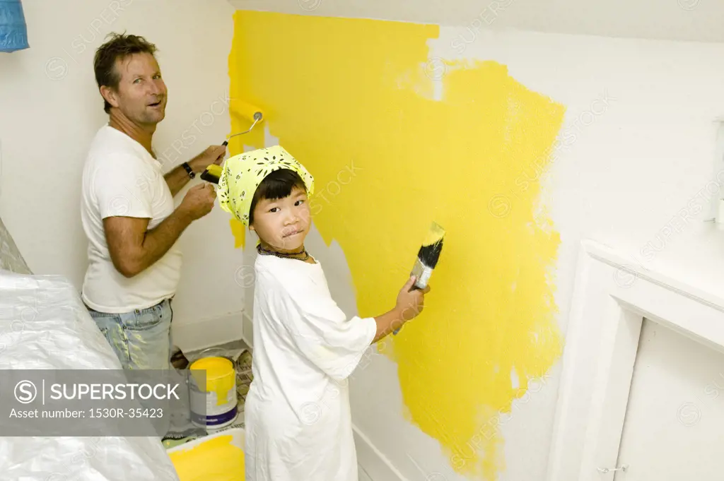 Man and child painting wall