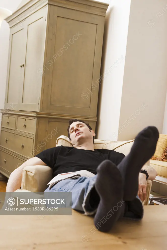 Man sleeping in chair with feet up