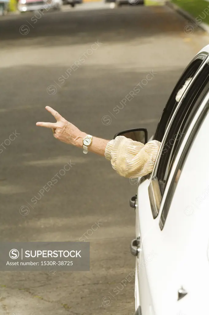 Senior womans arm sticking out of car