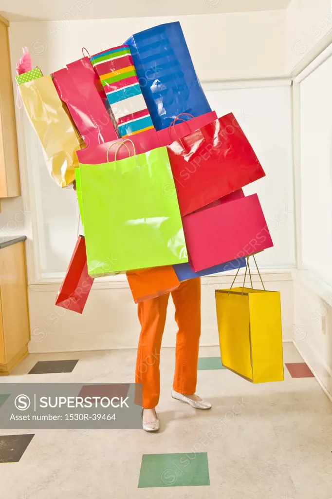 Woman balancing assorted shopping bags