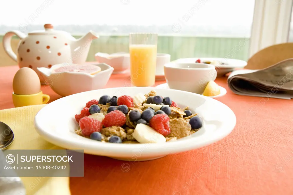 Healthy breakfast of dry cereal and fruit with egg and juice
