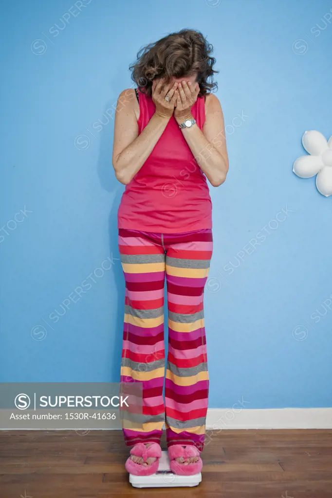 Upset woman standing on scales