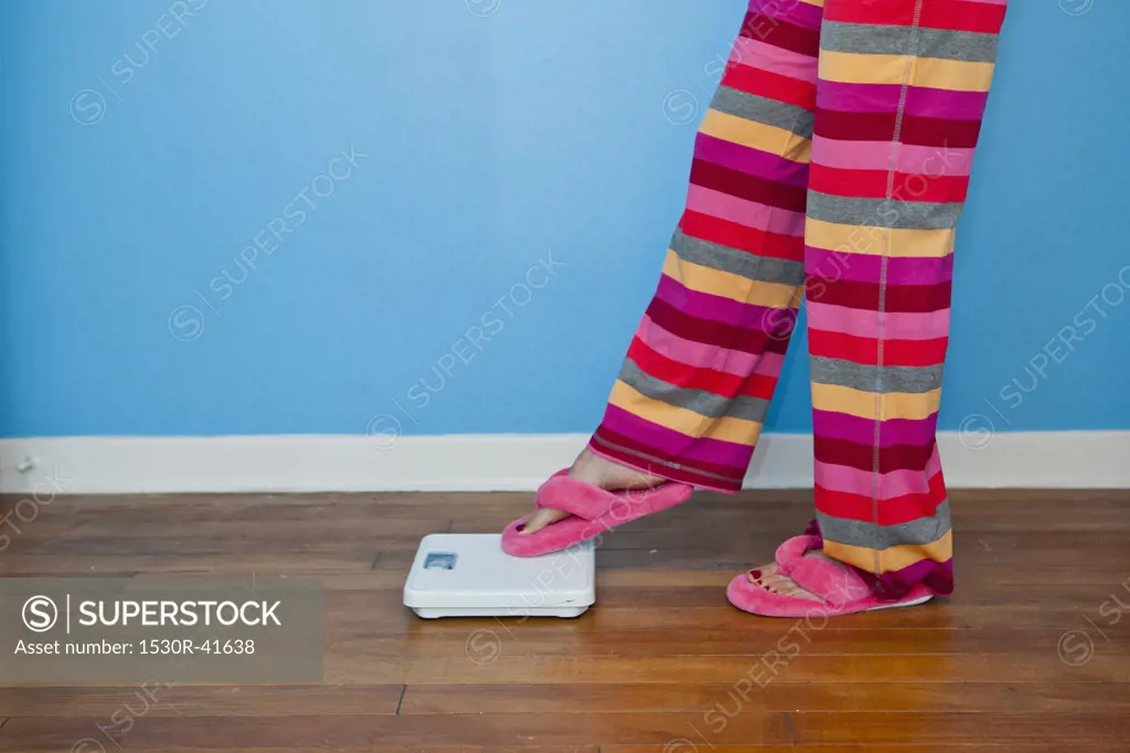 Woman putting toe on scales