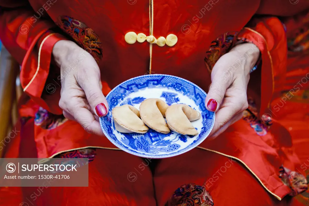 Woman holding plate of fortune cookies,