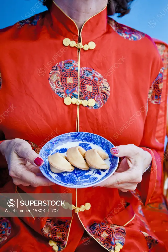 Woman holding plate of fortune cookies,