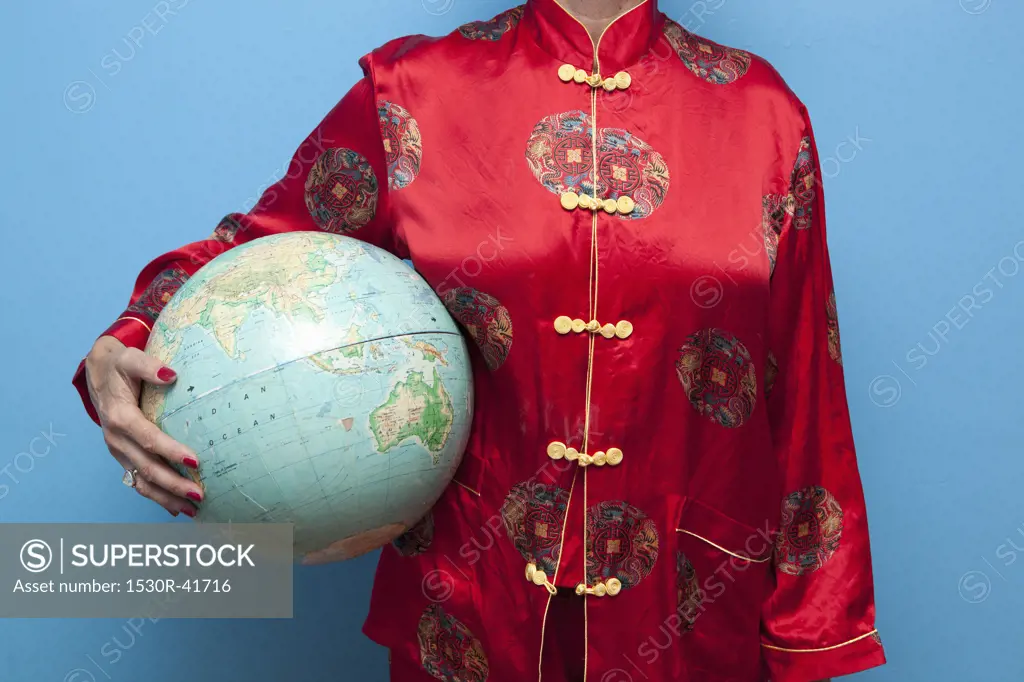 Woman in Chinese pajamas holding globe,