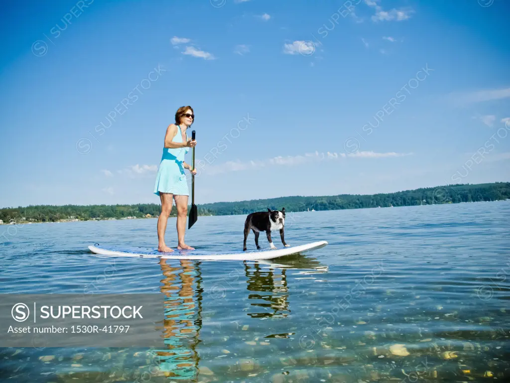 Woman on paddle board with dog,