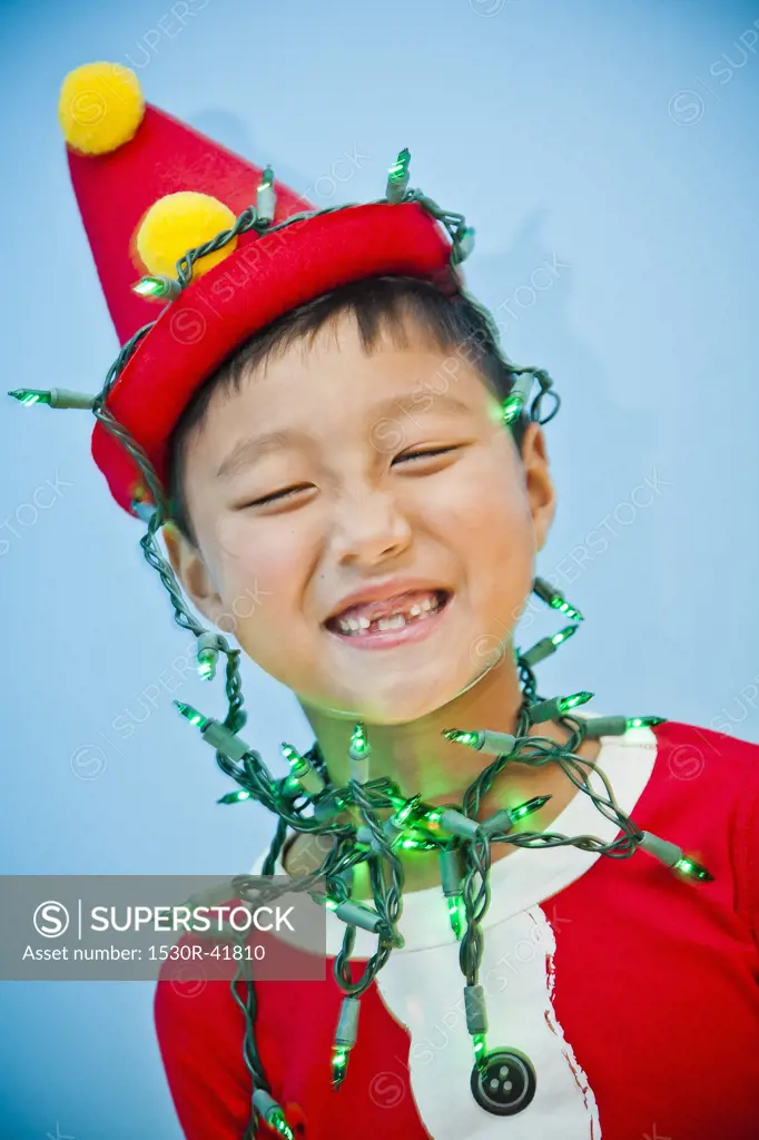Boy in red costume with holiday lights,